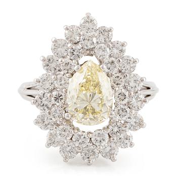 605. A platinum ring set with a pear-shaped yellow diamond and round brilliant-cut diamonds.
