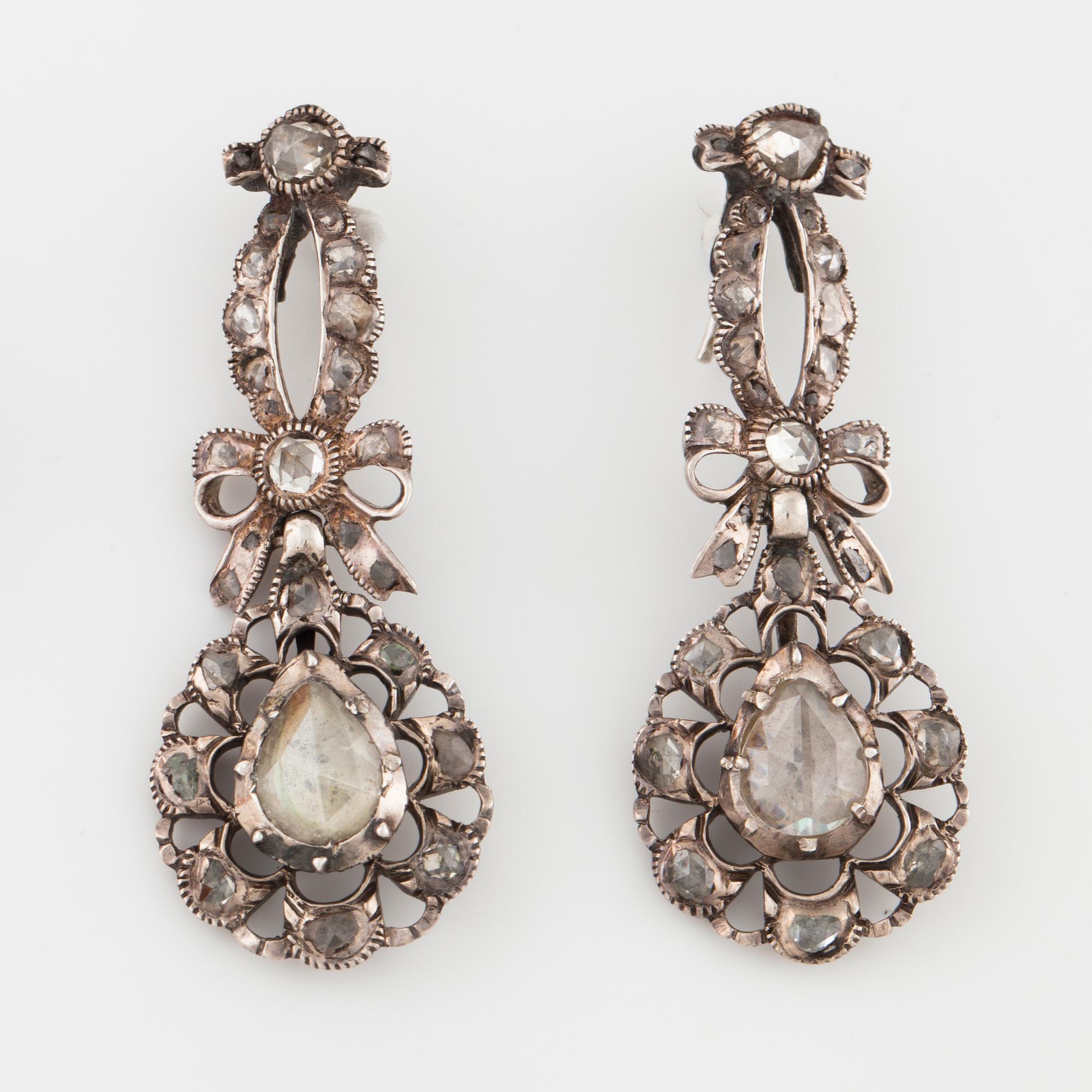 A pair of earrings and a brooch set with rose cut diamonds.