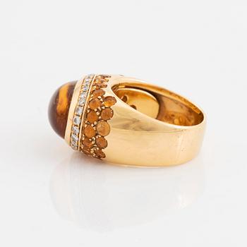 An 18K gold ring set with a cabochon-cut citrine and round brilliant-cut diamonds och citrines.