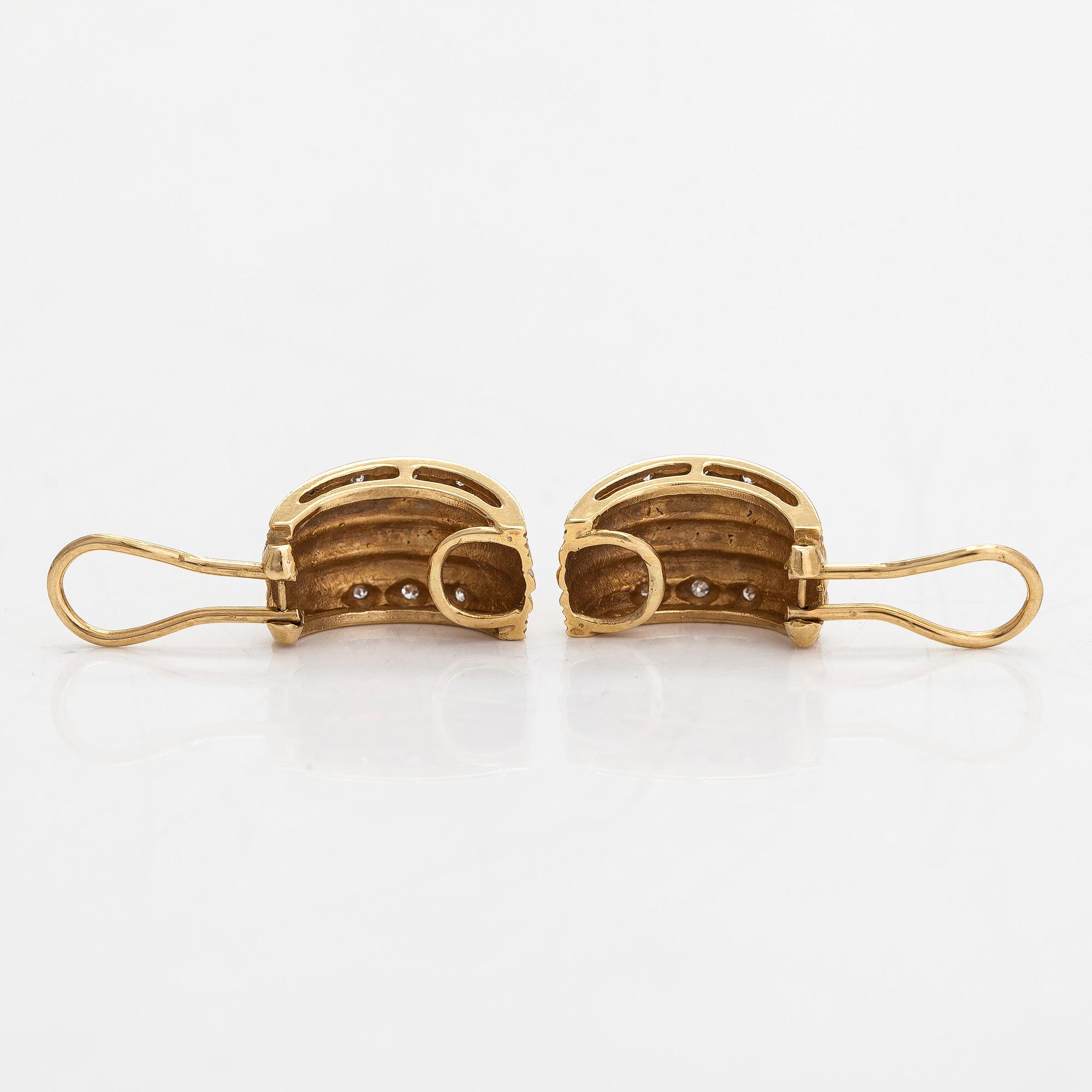 A pair of 18K gold earrings set with small diamonds.