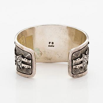 A silver bracelet with coral.