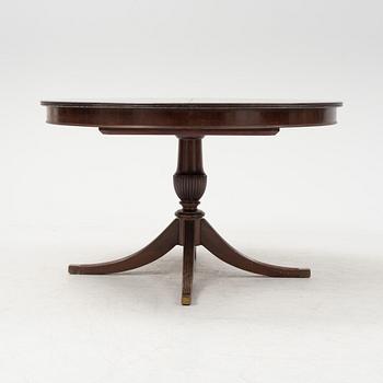 A round mahogany dining table with three additional leaves.