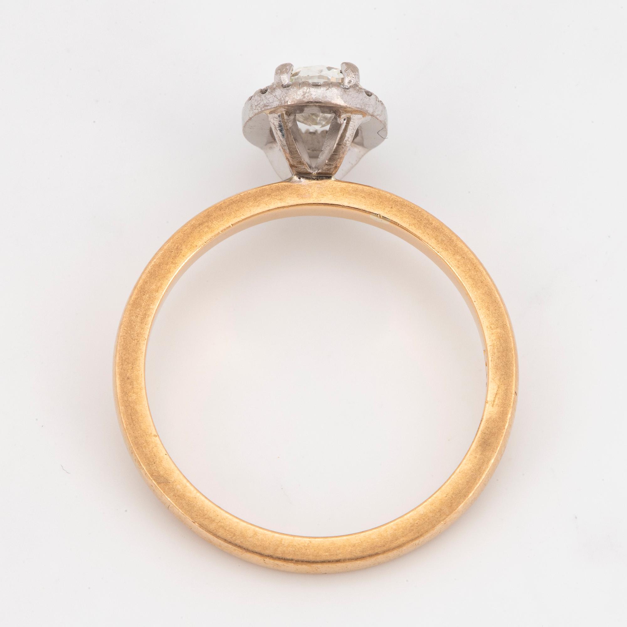 An 18k gold ring set with an oval brilliant-cut diamond.