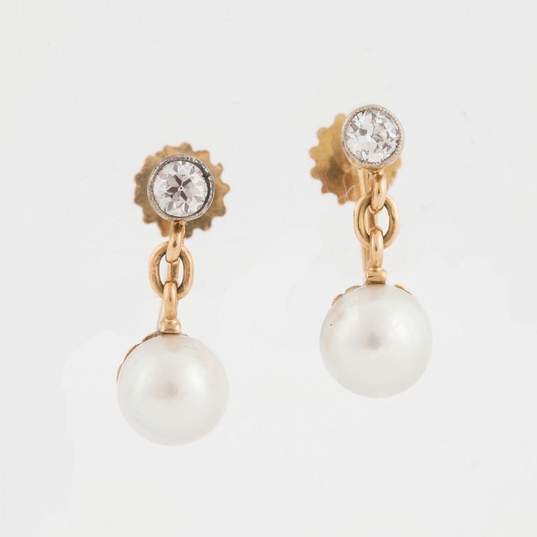 A pair of earrings set with cultured pearls and old-cut diamonds.