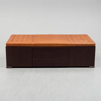 A contemporary bench with drawers and leather upholstery.