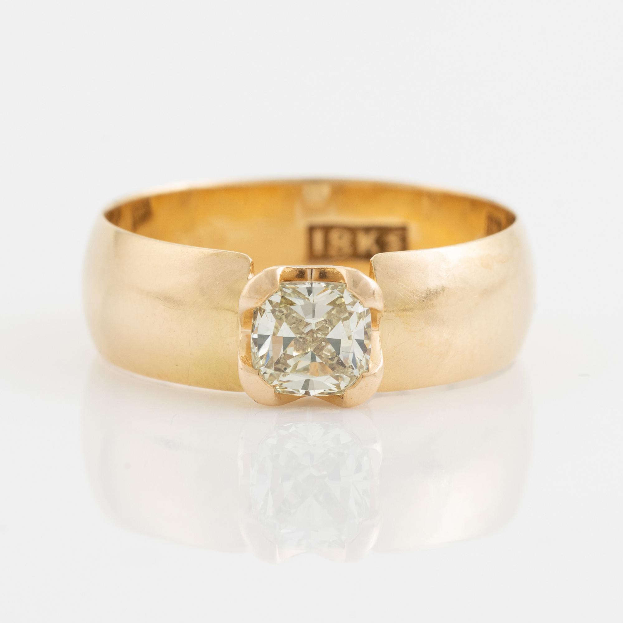 An 18K gold ring set with a radiant-cut diamond.