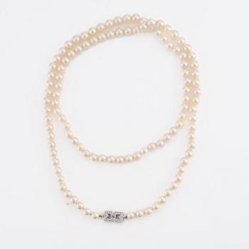 Pearl necklace, longer model, cultured pearls, clasp in 14K white gold with baguette and brilliant-cut diamonds.