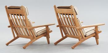 A pair of Hans J Wegner oak and fabric easy chairs, Getama, Gedsted, Denmark 1950's-60's.