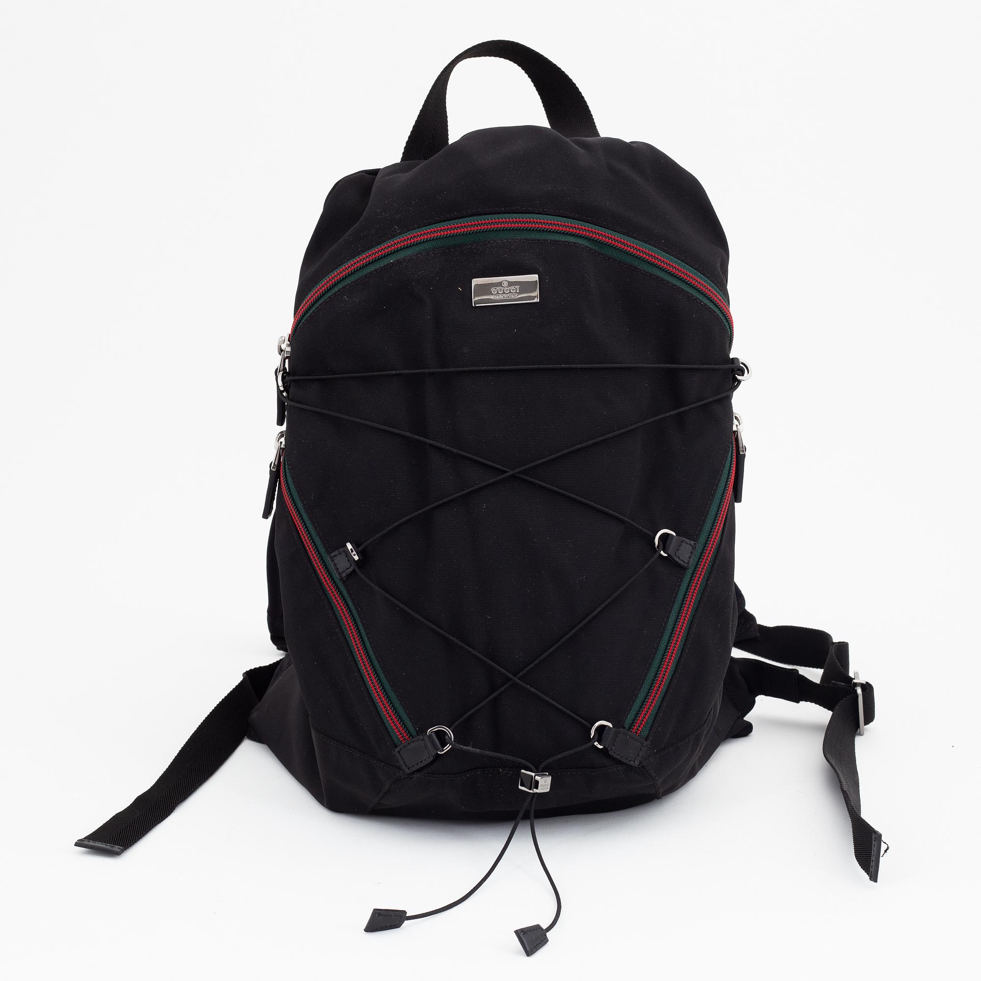Gucci, a black canvas backpack.