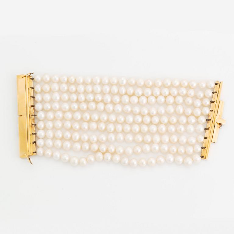 A nine strand cultured fresh water pearl bracelet with  clasp in 18K gold.