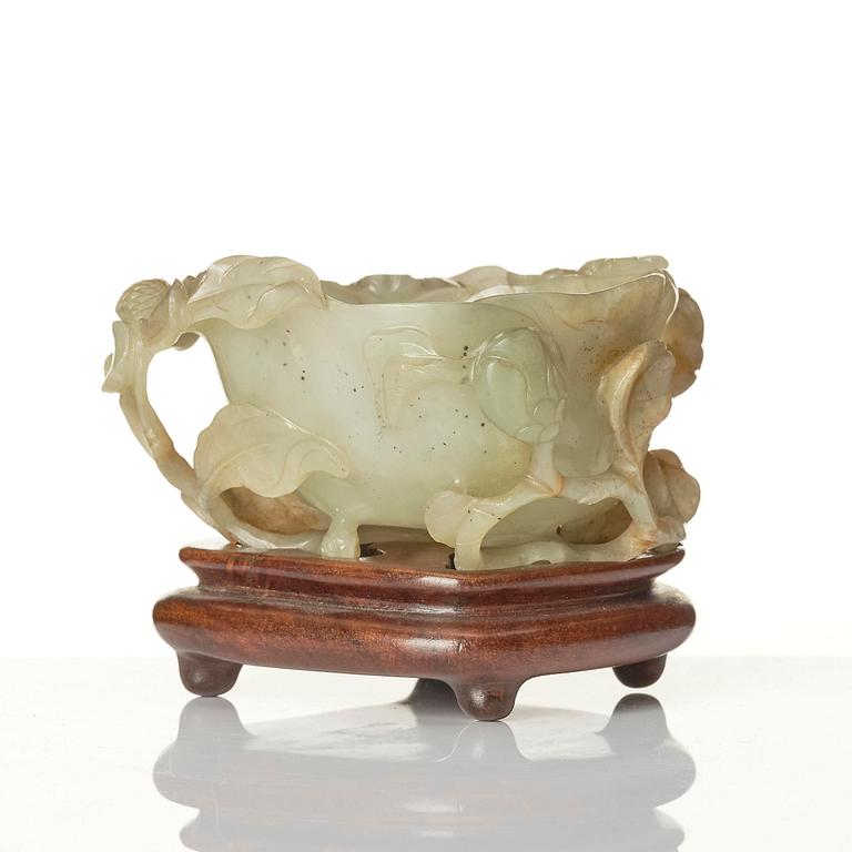 A carved Chinese nephrite cup in the shape of a lotus leaf, late Ming dynasty.