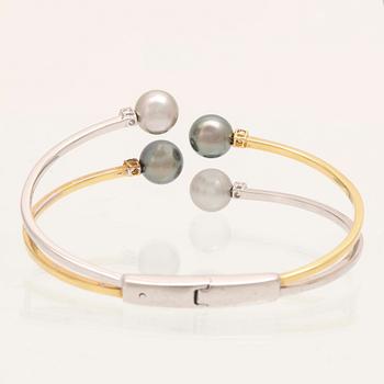 An 18K white- and yellow gold bracelet with round brilliant cut diamonds and cultured Tahitian pearls, Damiani Italy.