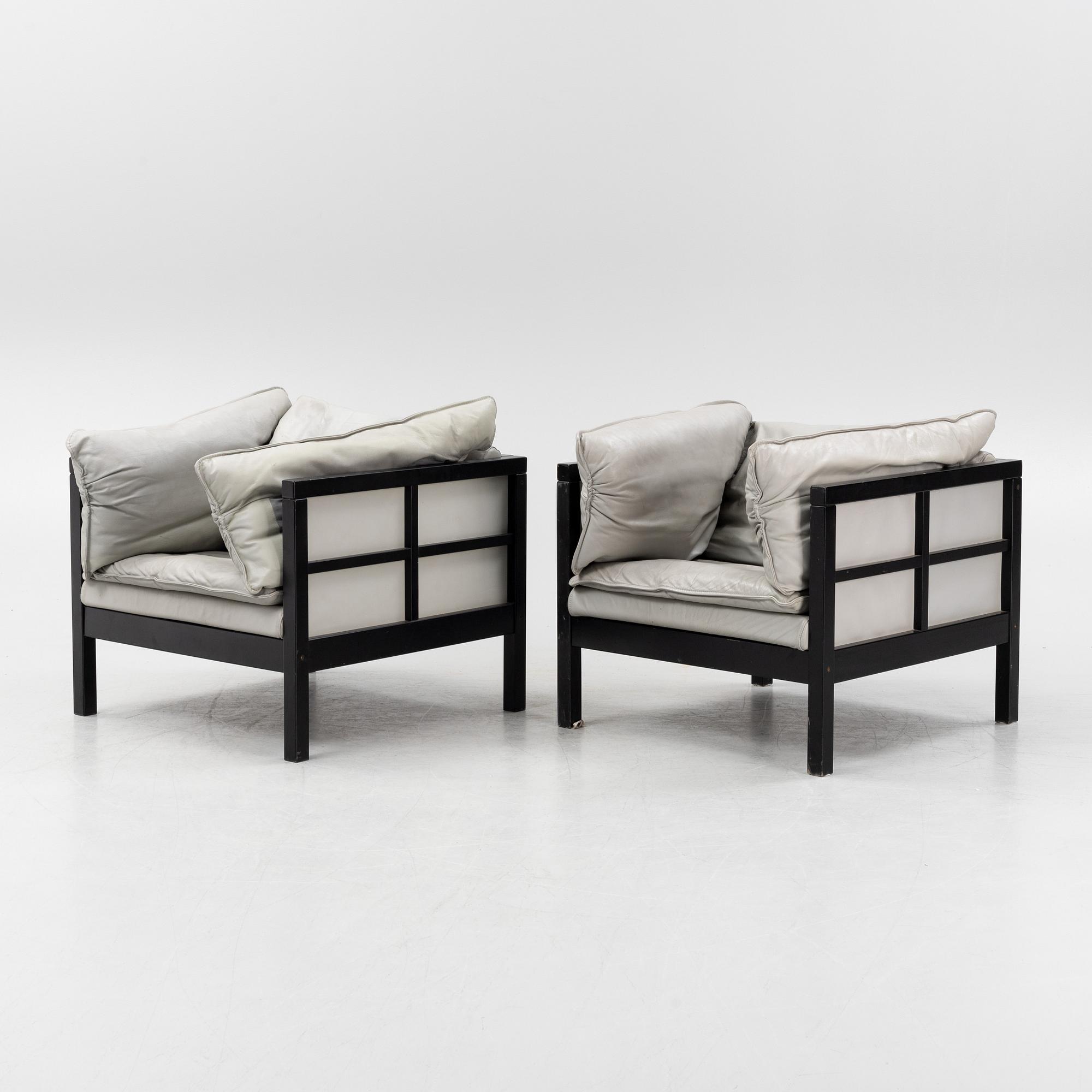 A pair of leather upholstered armchairs. End of the 20th Century.