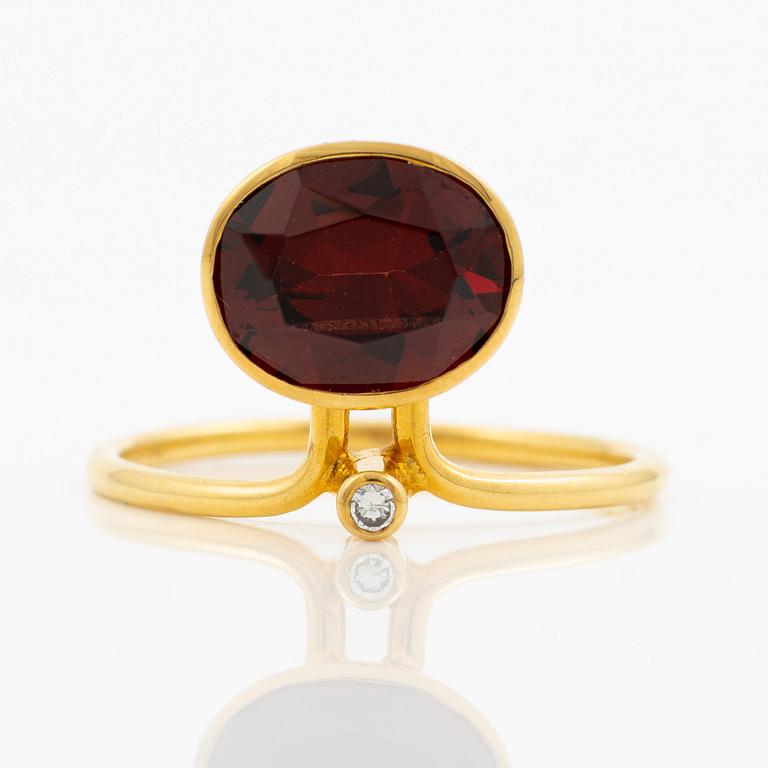 Ring in 18K gold with an oval faceted garnet and a brilliant-cut diamond.