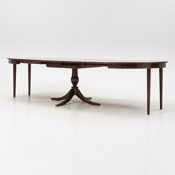 A round mahogany dining table with three additional leaves.