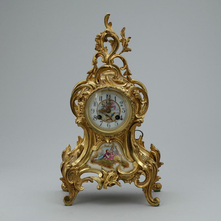 GARNITYR MED BORDSPENDYL OCH ett par KANDELABRAR, mässing, Louis XV-stil, troligen omkring 1900.