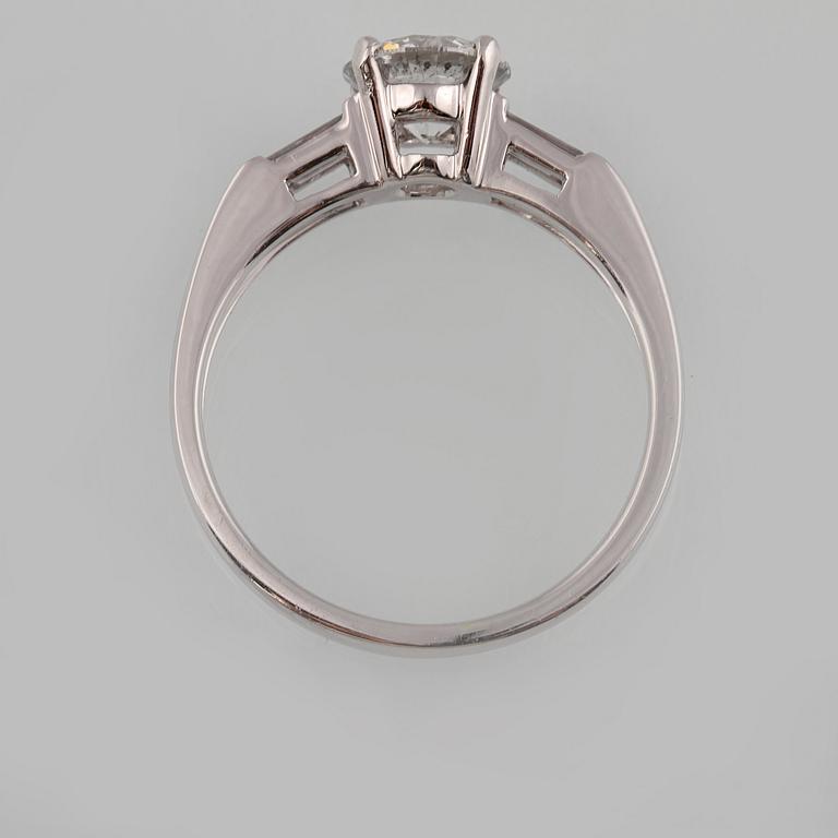 RING, 18K vitguld med briljantslipad diamant ca 1.05 ct samt 2 baguettslipade diamanter ca 0.17 ct. Vikt 3,2 gram.