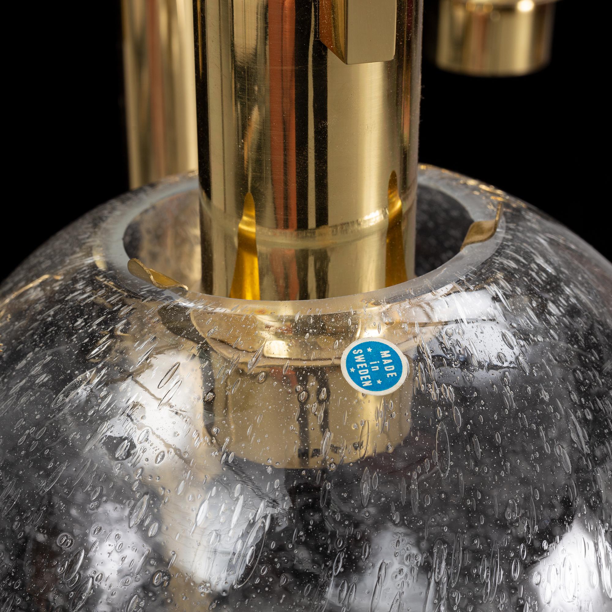 A brass chandelier with two glass globes by Hans-Agne Jacobsson, Markaryd.