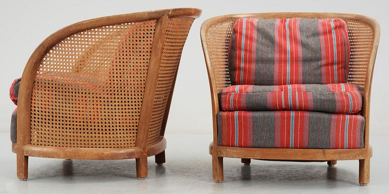 A pair of Oscar Nilsson beech and rattan arm chairs.