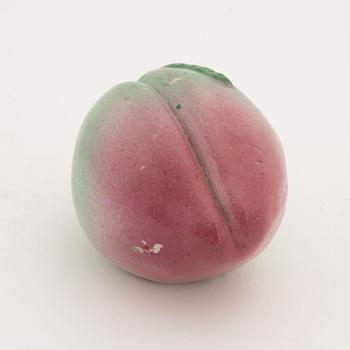 A Chinese porcelain figure of a peach, Qing dynasty, circa 1900.