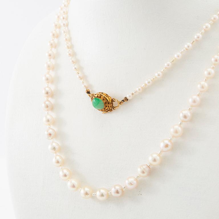 Necklace of cultured pearls with a clasp of 18K gold and cabochon-cut green stone.