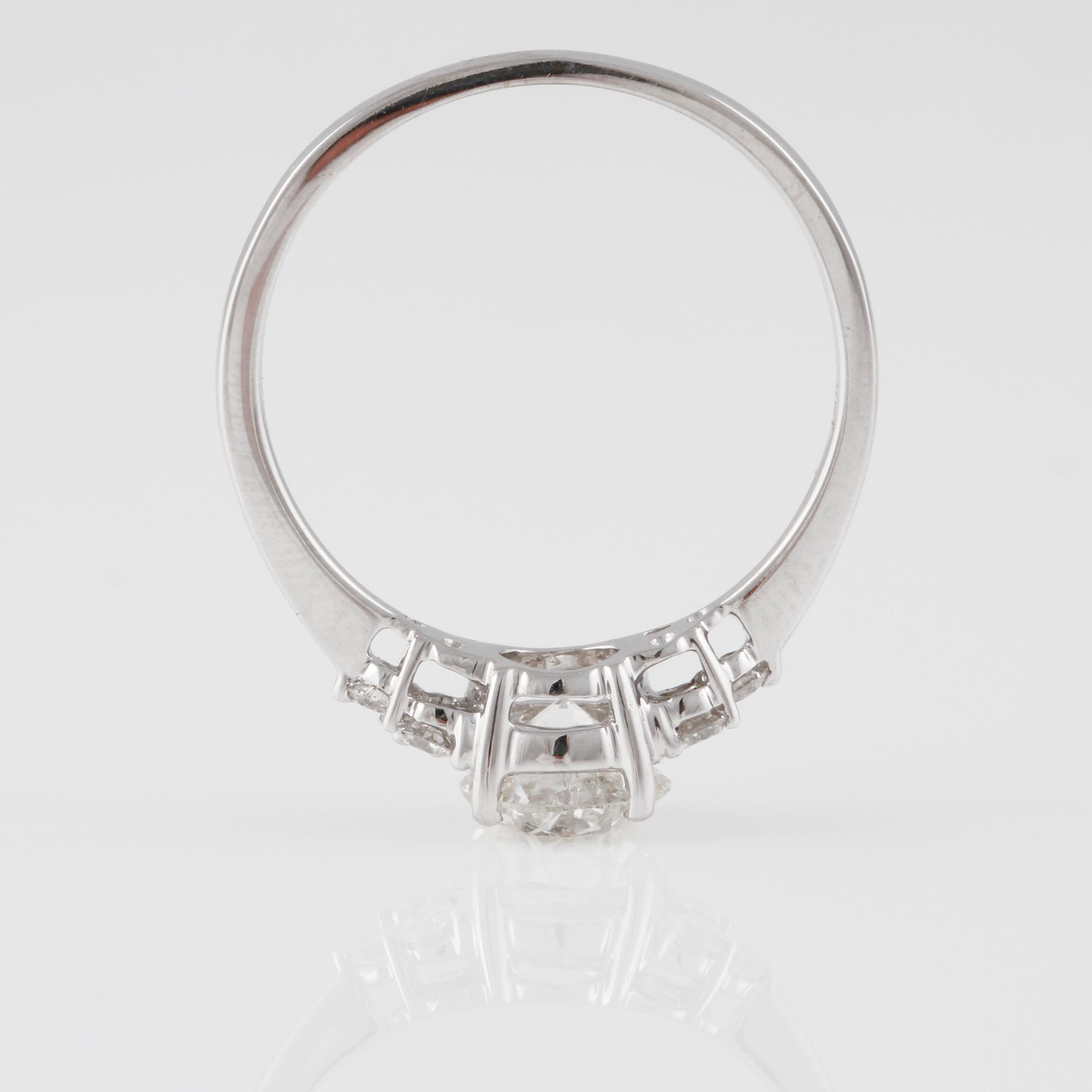 RING, 18K vitguld med briljantslipad diamant ca 0.97 ct och små briljantslipade diamanter ca 0.16 ct. Vikt 2,6 gram.