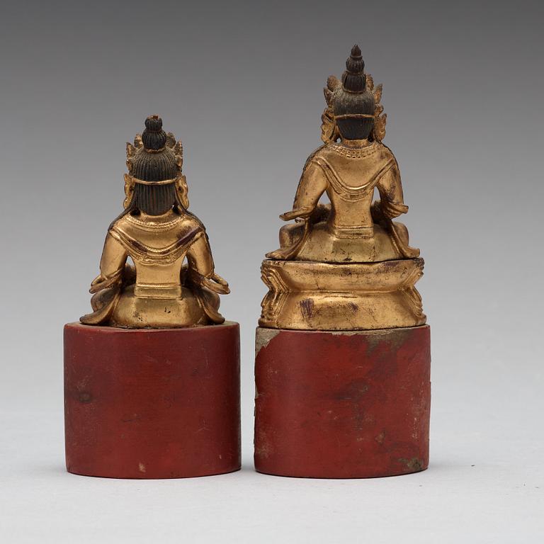 Two Sino-tibetan wooden and lacquered figures of buddha, late 19th Century.