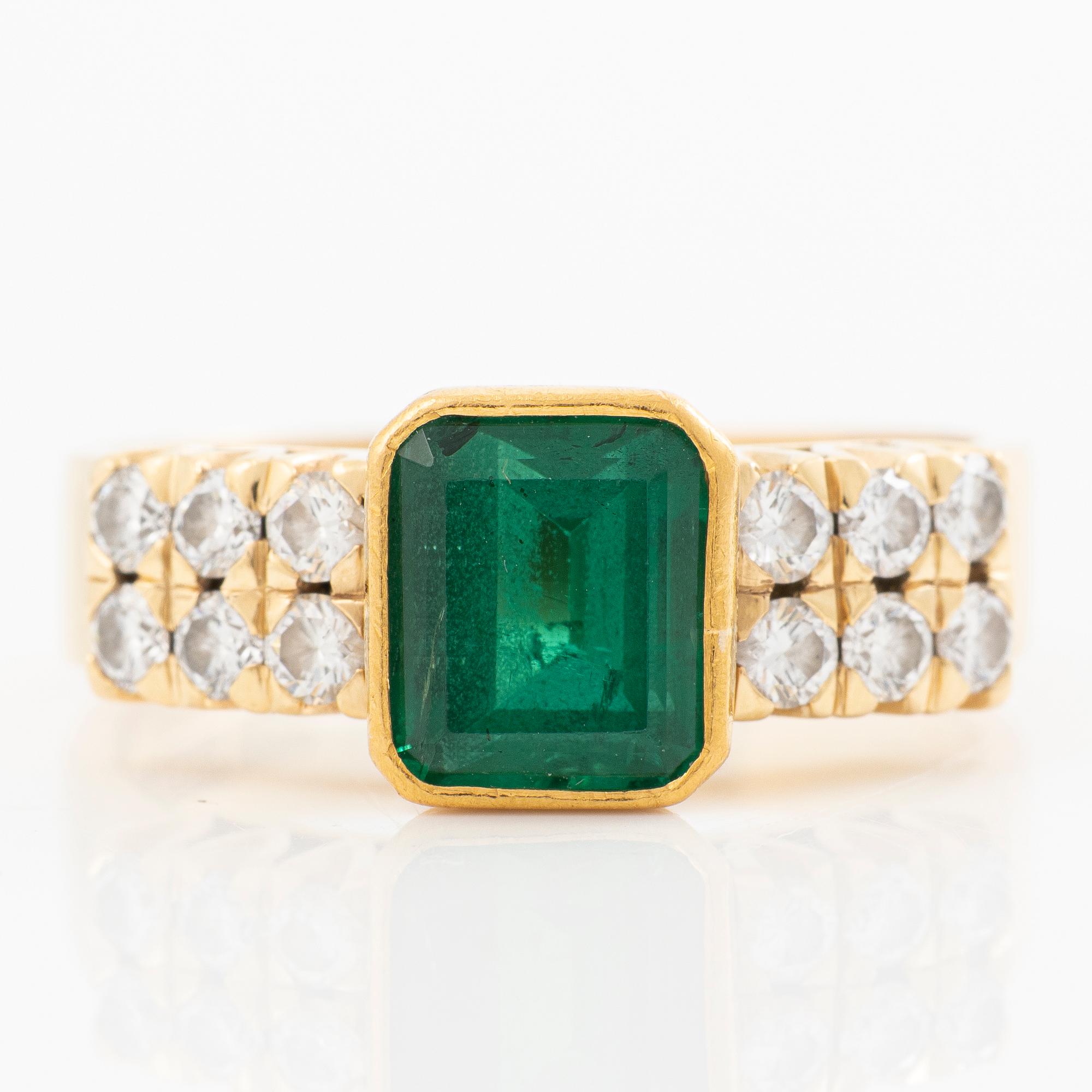 Ring 18k guld med en fasettslipad smaragd och runda briljantslipade diamanter.