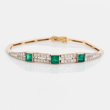 An 18K gold and platinum bracelet set with step-cut emeralds and old- and eight-cut diamonds.