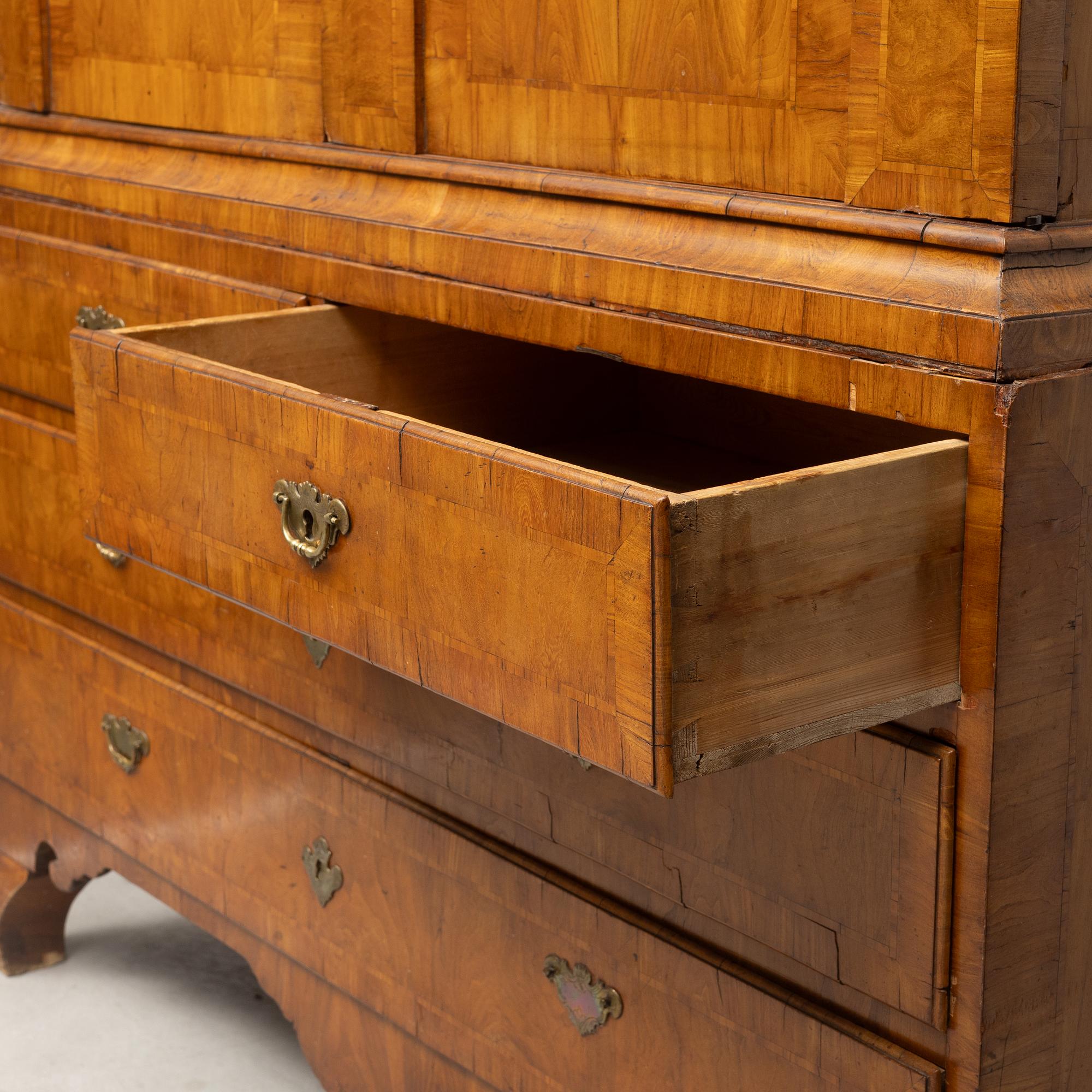 A late Baroque walnut-veneered cabinet in the manner of J. H. Fürloh, mid 18th century.