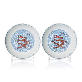 A pair of blue and white and iron red decorated dragon dishes, Qing dynasty with Daoguang mark.