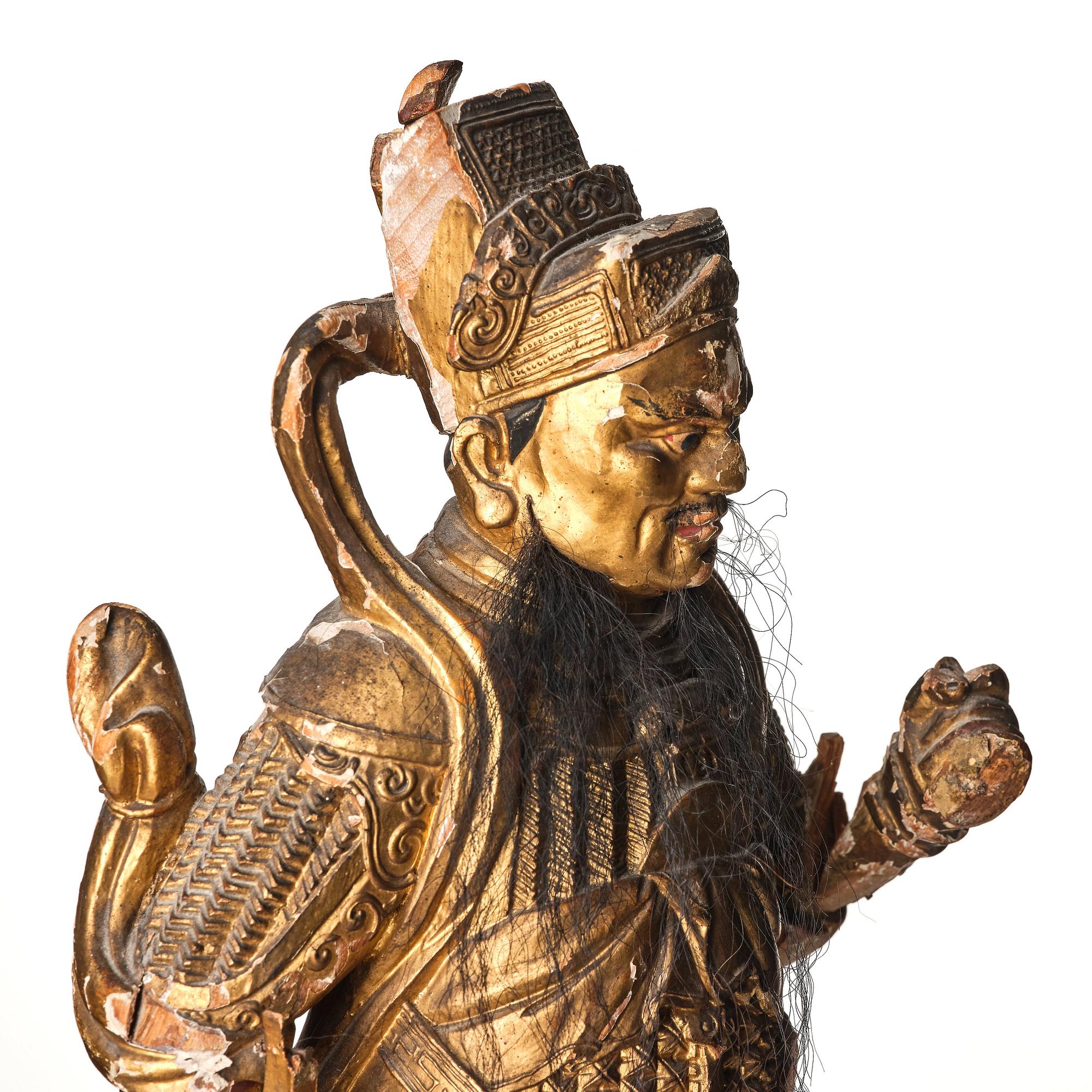 A gilt and lacquered standing figure of a guardsman, Qing dynasty.
