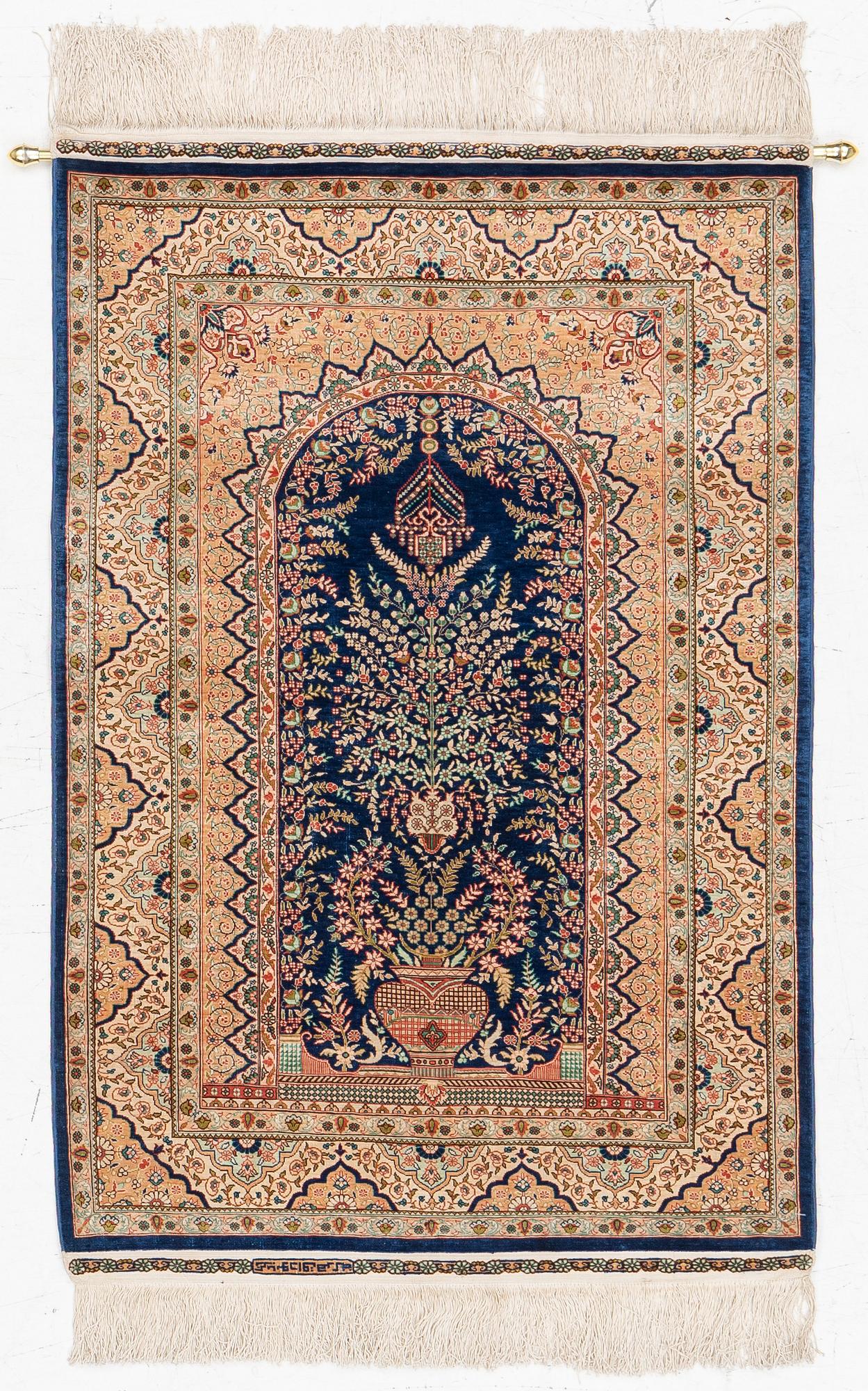 A semi-antique silk Hereke rug, West Anatolia, signed c. 107 x 72 cm.