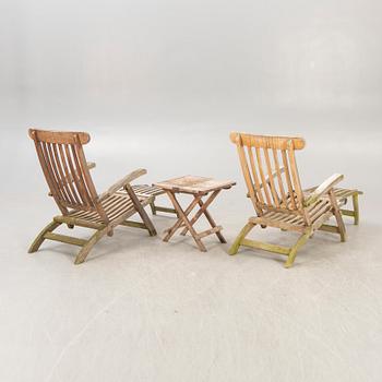 A pair of teak deck chairs and table later part of the 20th century.