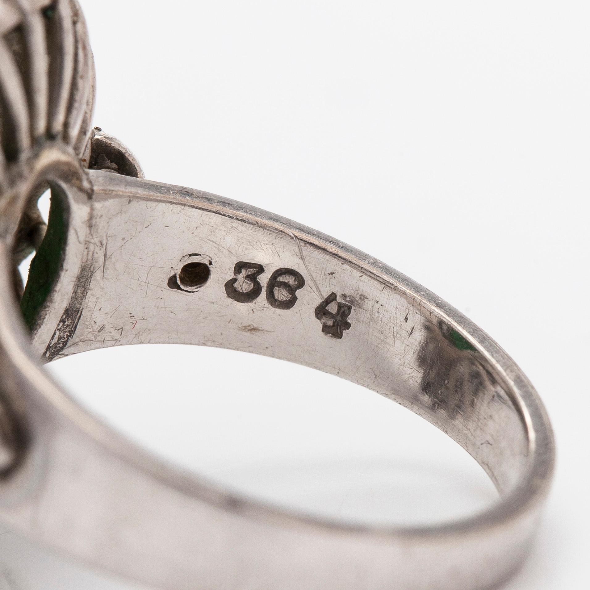 A palladium-plated silver ring with cabochon-cut jadeite and diamonds.
