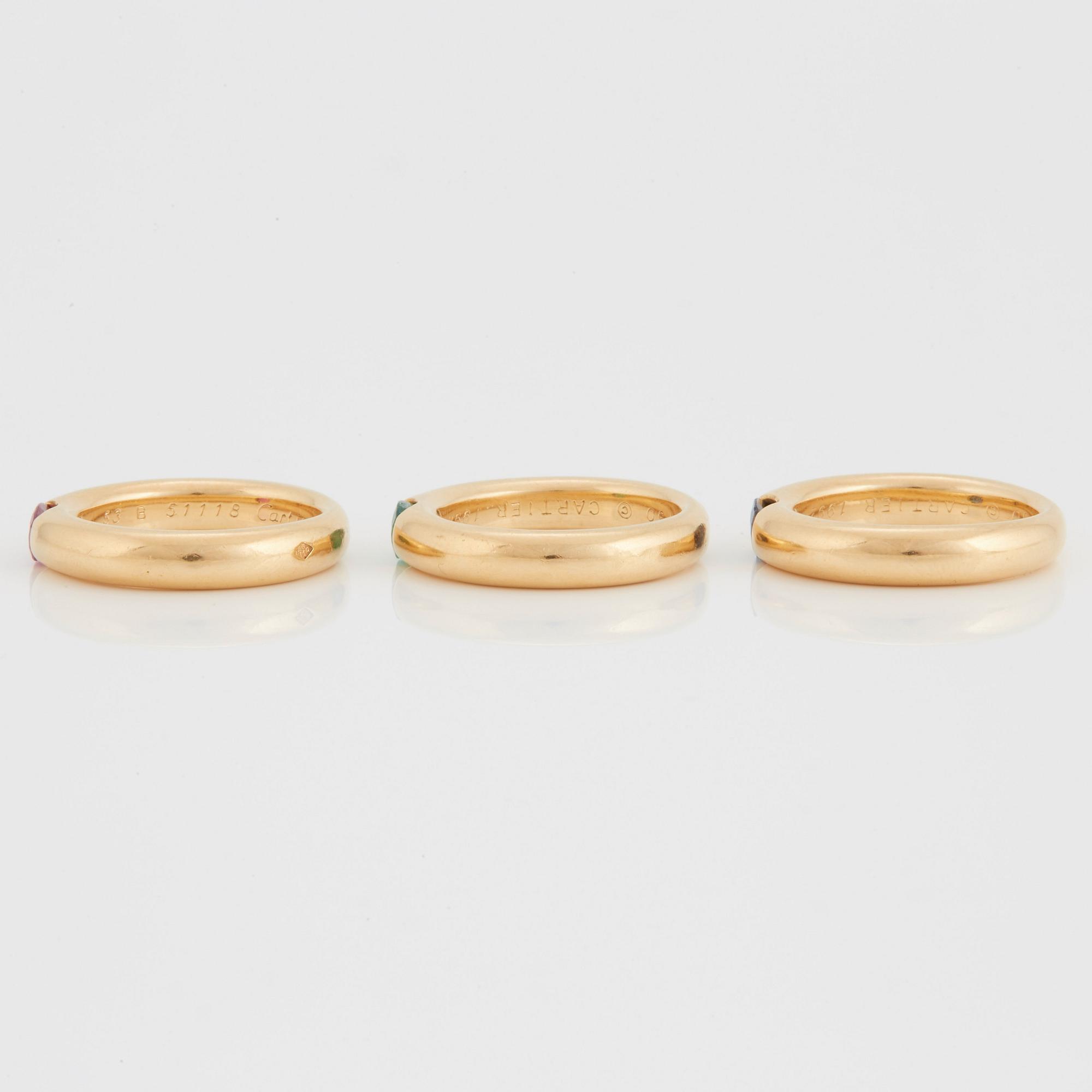 Cartier tre ringar "Ellipse" 18K guld med fasettslipad safir, smaragd och rubin.