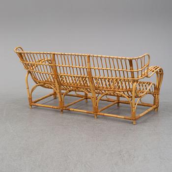 A rattan and glass table and a rattan sofa, second half of the 20th century.