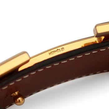 HERMÈS, a reversible belt, togo orange and brown with gold colored  H belt buckle.