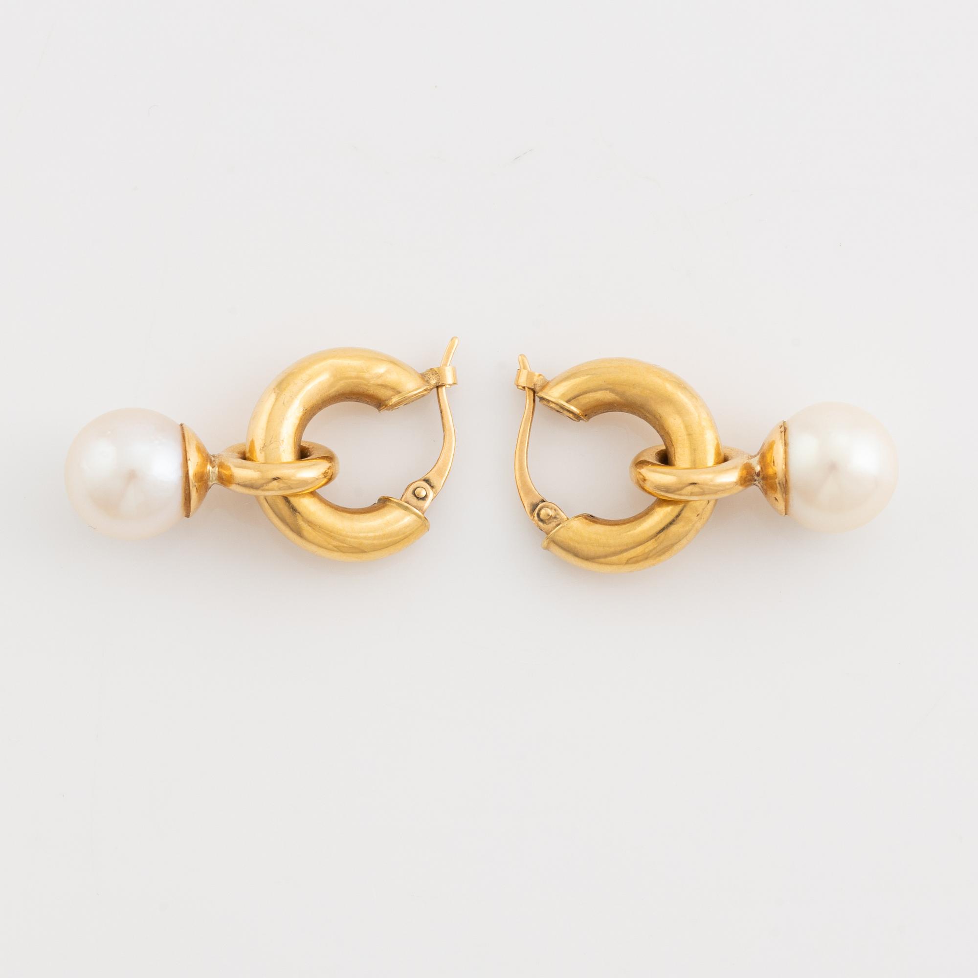 A pair of gold earrings with pearls.