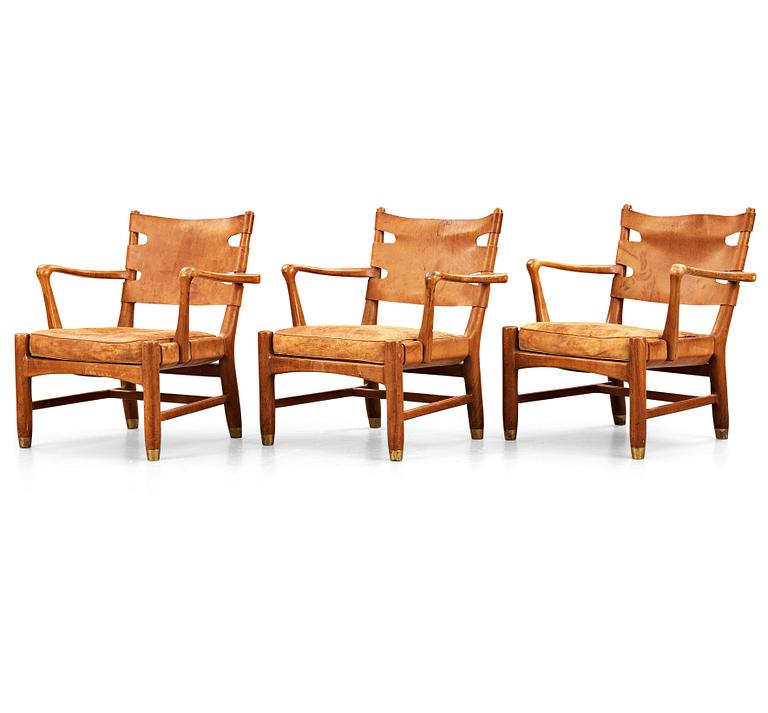 SCANDINAVIAN MODERN, a set of three mid 20th century mahogany and brown leather easy chairs.