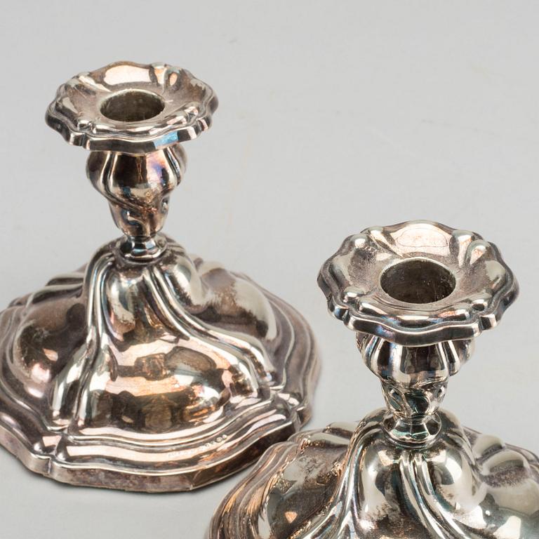 A PAIR OF SILVER ROCOCO STYLE CANDLE STICKS.