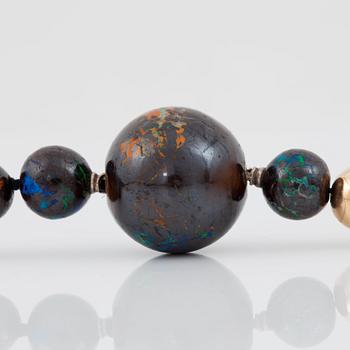 A necklace with beads of boulder opals, Ø 17.3-5.3 mm and gold beads. Made by Gaudi, Stoclkholm 1989.