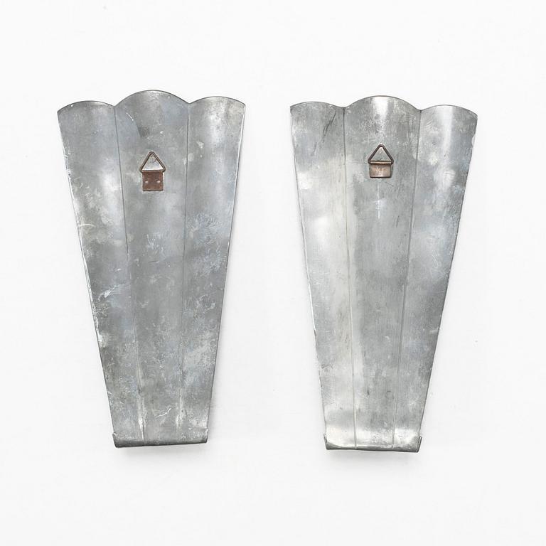Nils Fougstedt, a matched pair of pewter and brass wall sconces, model A 60, Svenskt Tenn, Stockholm 1929 and 1932.