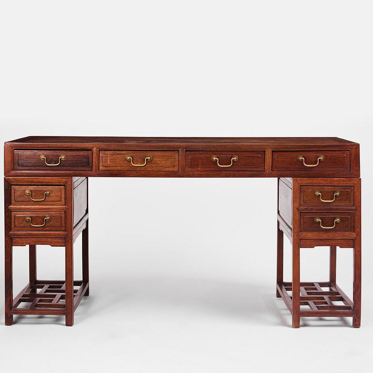 A six-drawer 'jichimu' pedestal partners desk, late Qing dynasty/early 20th century.