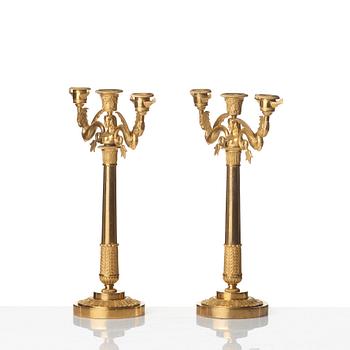 A pair of Empire early 19th century gilt bronze three-light candelabra.