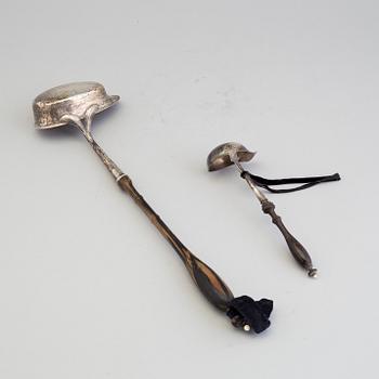 A 19th century silver soup and a sauce ladle with wooden handles.