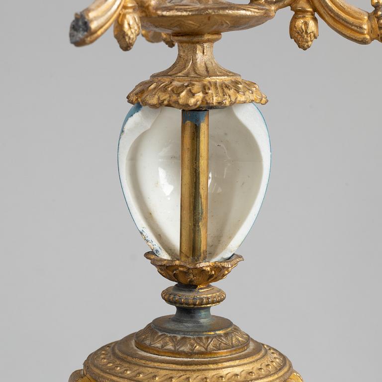 A Louis XVI style mantel clock and a pair of candelabra, circa 1900.