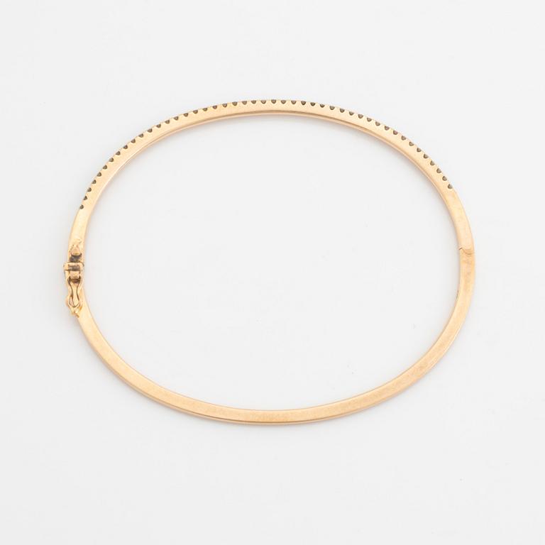 An 18K rose gold bangle set with round brilliant-cut diamonds.