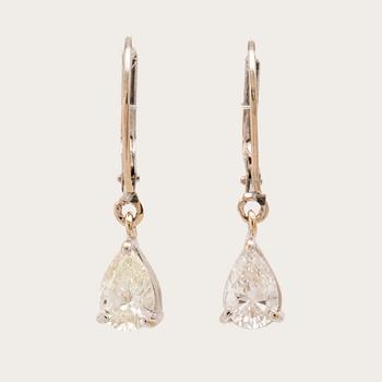 A pair of 18K white gold earrings set with pear cut diamonds.