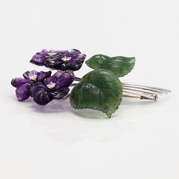 A flower brooch made of 18K white gold, carved amethysts and nefrites with ca. 0.64 cts of diamonds.